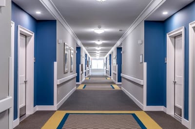 Brightly lit interior hallway of a senior living facility