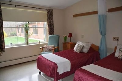 A shared resident room with two beds and a view