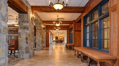 Welcoming hallway with wooden beams and chandeliers