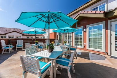 Outdoor dining area with teal umbrellas and seating