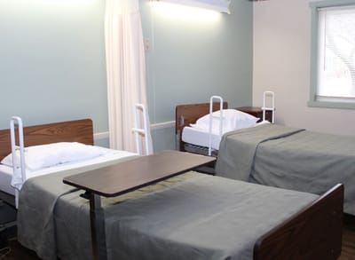A shared resident room with two beds and a table