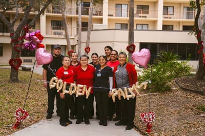Staff celebrating with a banner in the courtyard