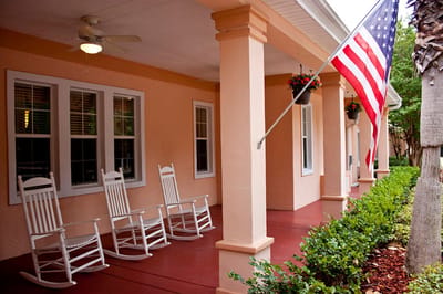 Front porch with rocking chairs and American flag