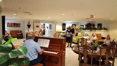 Residents enjoying live music in the facility lounge