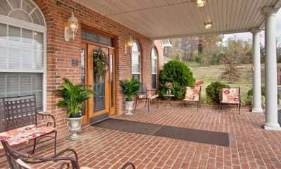 Front entrance of a welcoming assisted living facility with seating area