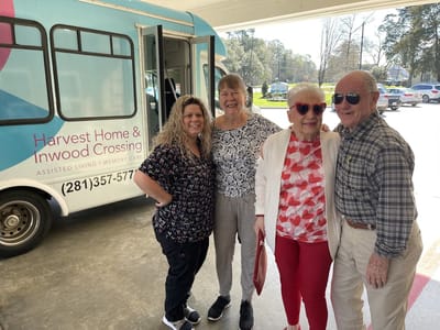 Residents and staff by the facility's transportation van