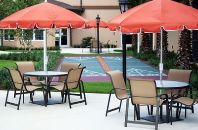Outdoor seating area with red umbrellas and lawn
