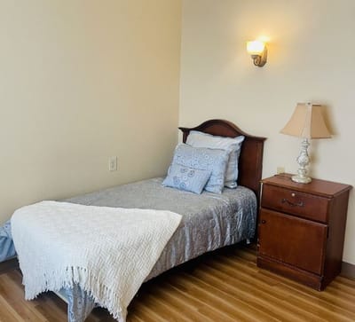 A cozy bedroom with a bed and bedside lamp