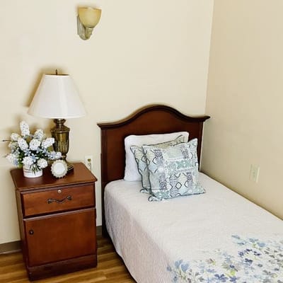 Cozy private room with a bed and bedside lamp