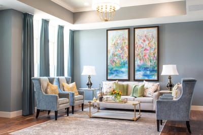 Bright common area with comfortable seating and floral artwork