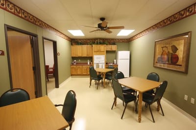 Common area with tables and chairs in a senior living facility