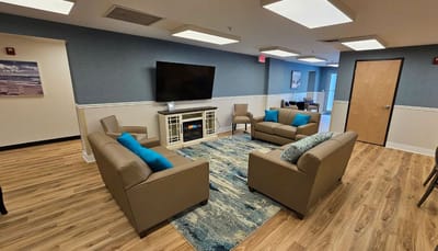 Bright common area with modern furnishings and a TV