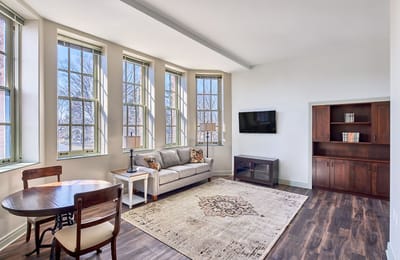 Bright, spacious resident room with a sofa and dining table