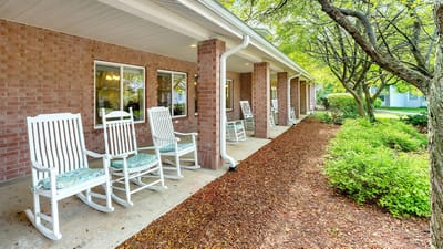 Outdoor seating area with rocking chairs and greenery