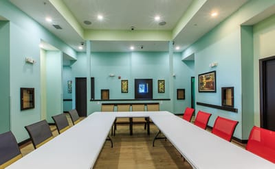 Brightly colored activity room with tables and chairs