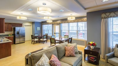 A bright common area with seating and dining tables