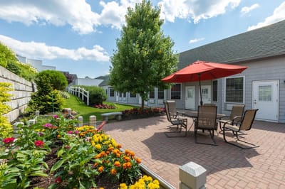 Outdoor seating area with colorful flowers and a patio umbrella