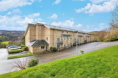 Exterior view of the assisted living facility surrounded by greenery