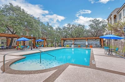 Outdoor pool area with seating and umbrellas