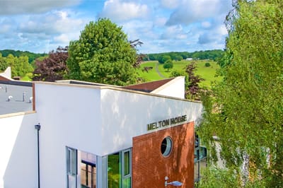 Exterior view of Melton House surrounded by greenery