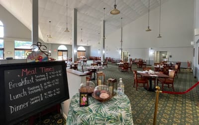 Dining room with tables set for meals and menu board
