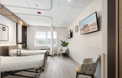 A brightly lit shared room with two beds