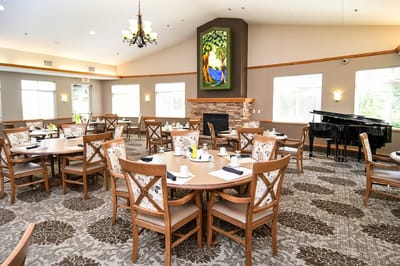 Dining room with tables set for meals and a piano