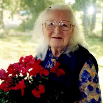 Resident holding flowers with a warm smile