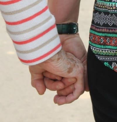 Two hands holding each other in a caring gesture