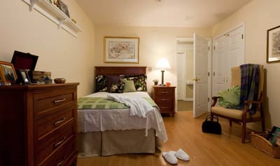 Cozy private room with a bed, dresser, and chair