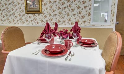 Dining table set with red plates and napkins