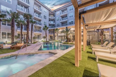 Outdoor pool area with lounge chairs and palm trees
