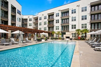 Outdoor pool area with seating and palm trees