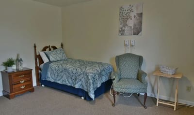 Private resident room with a bed and chair