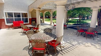Outdoor seating area with tables and chairs under a gazebo