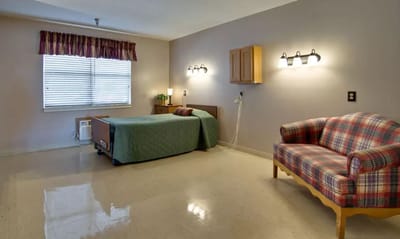 Brightly lit resident room with a bed and couch
