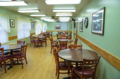 Well-lit dining area with wooden tables and chairs