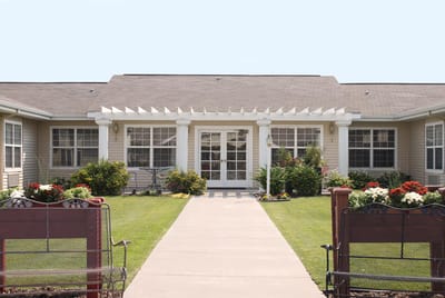 Front entrance of Pomerelle Place Senior Living with landscaped path