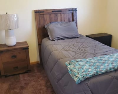 Cozy resident room with wooden furniture and bedding