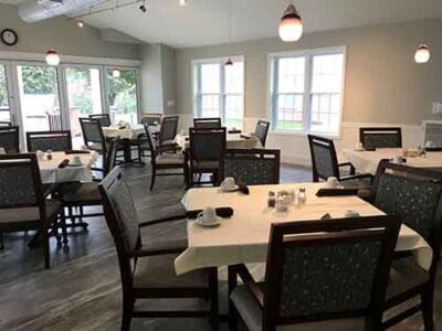 Bright dining area with tables and chairs set up.