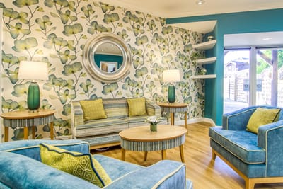 Bright common area with a floral wallpaper and seating