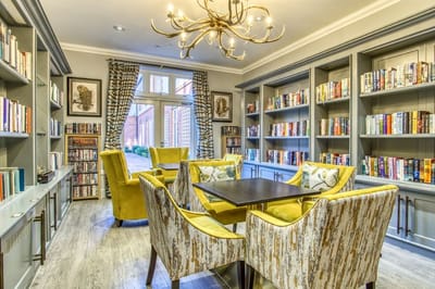 Bright common area with bookshelves and yellow chairs