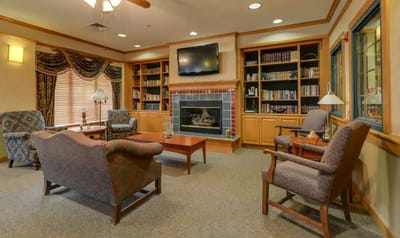 Warm common area with seating and a fireplace