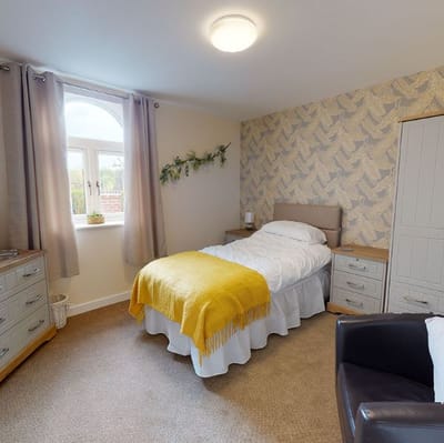 Cozy single bedroom with a bed and a chair