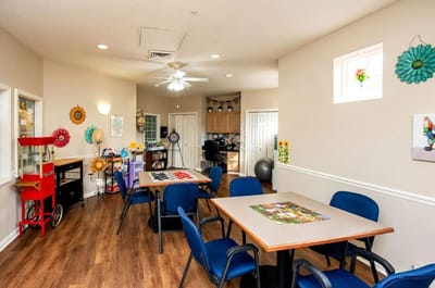 Bright activity room for residents with tables and games