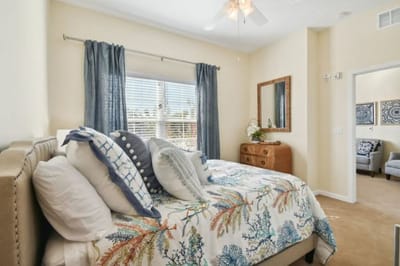 A cozy bedroom interior with floral bedding and natural light