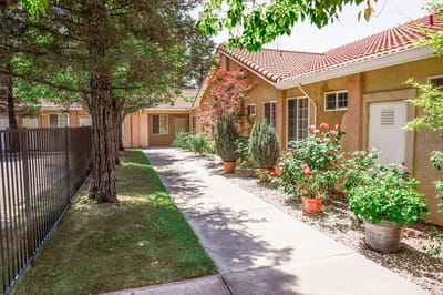 Pathway lined with flowers outside a senior care facility