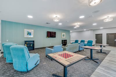 Bright common area with comfortable seating and game tables