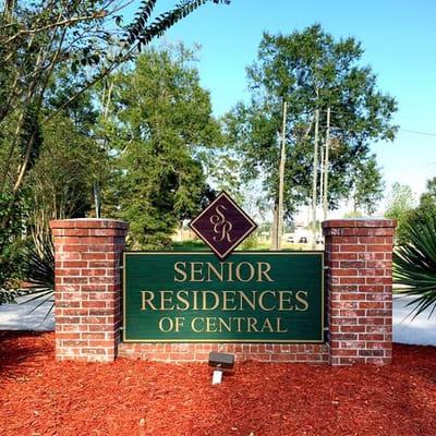 Sign for Senior Residences of Central surrounded by greenery