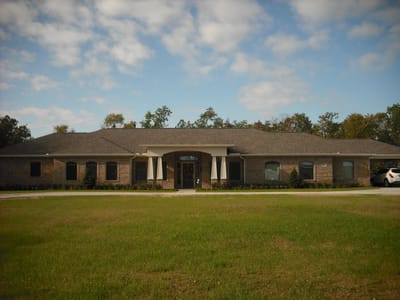 Exterior view of Serenity Gardens with lawn and trees